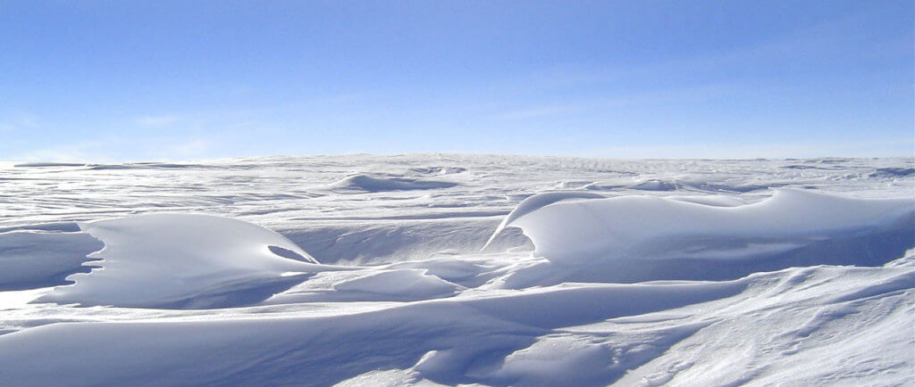 Sastrugi - snow dunes - in Antarctica on a sunny day.