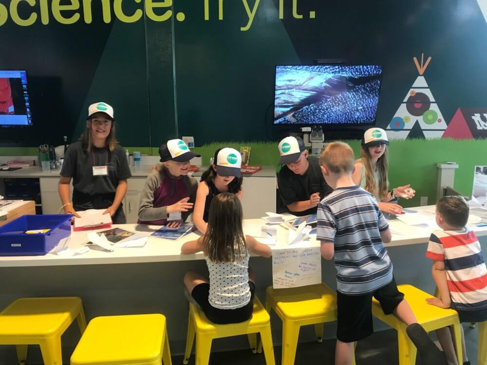 young women in science camp teaching young children about flight