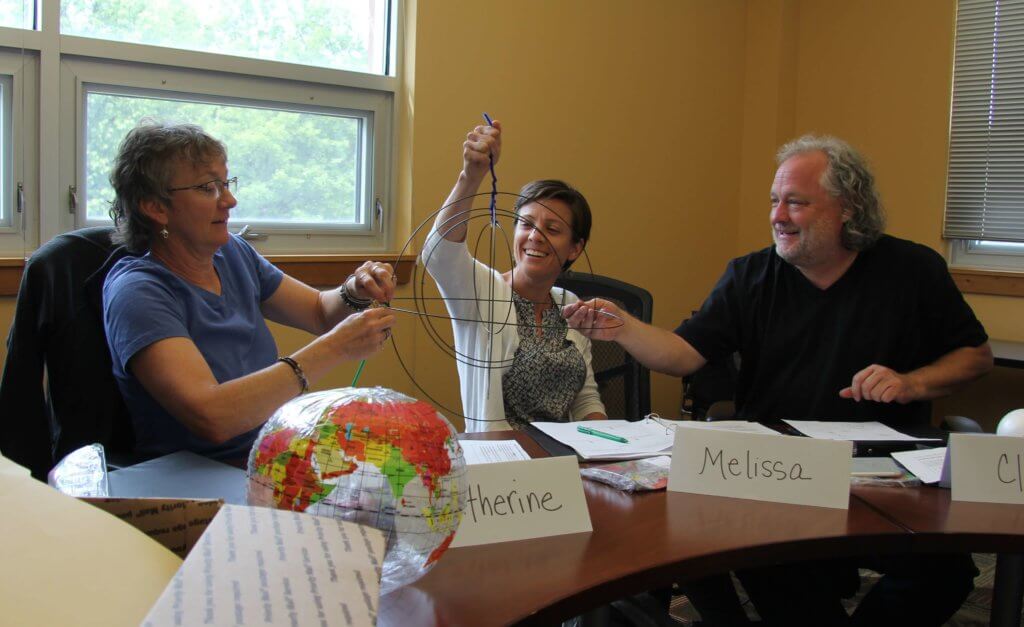 teachers in the Wings Over Water program experiment with a globe