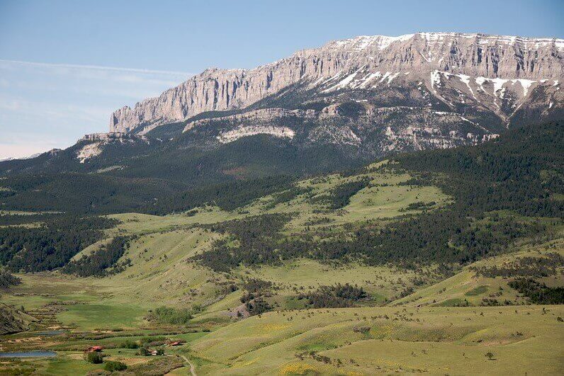 A phot of the Rocky Mountain Front with rolling grassland in the foreground