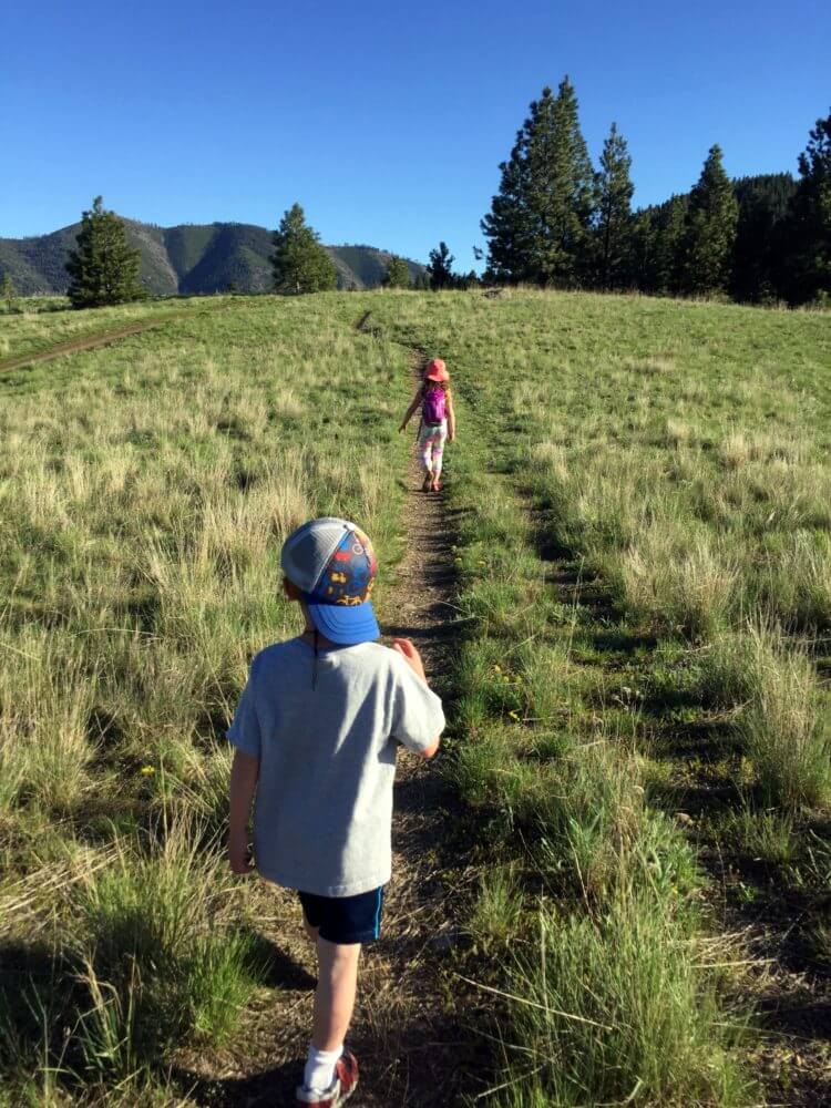 boy and girl walking on a grassy trail